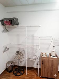 a white room with a fan and a shelf at Tu Refugio Acogedor a Pasos de Todo in Cochabamba