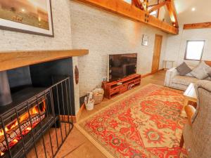 a living room with a fireplace and a tv at Old Riggs Paddock in Penrith