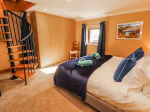 a bedroom with a bed with blue pillows and a staircase at Old Riggs Paddock in Penrith