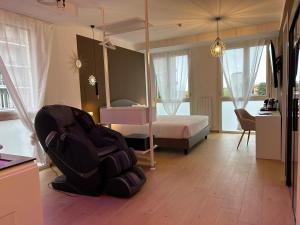 a room with a bedroom with a bed and a chair at 4 Star Suite SPA - Self Check-In in Bologna