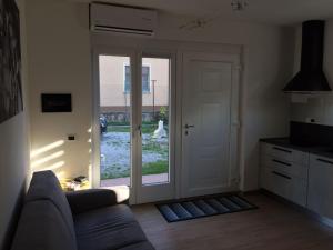 salon z kanapą i przesuwnymi szklanymi drzwiami w obiekcie Guest House Persico w mieście Desenzano del Garda
