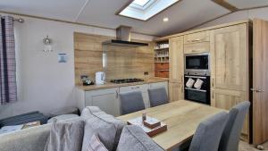 a kitchen with a table and chairs in a room at Rocco Family Retreat, Green Lawns in Selsey