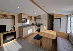 a kitchen and living room with a wooden table at Nirvana, Smells Like Holiday Spirit, West Sands in Selsey