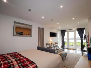 a bedroom with a large bed and a living room at Faodail Studio in Portree