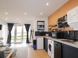 a kitchen with a washer and dryer in it at Faodail Studio in Portree