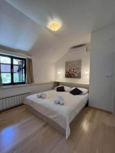 a bedroom with a large white bed and a window at HH Antona with Private Pool in Puljane