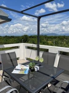 a black table and chairs on a balcony at HH Antona with Private Pool in Puljane