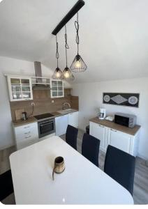 a kitchen with a white table and blue chairs at HH Antona with Private Pool in Puljane