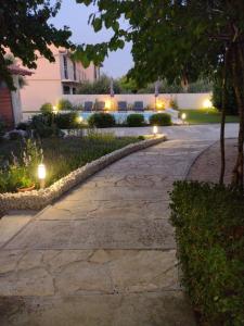 a stone walkway with lights in a yard at night at HH Antona with Private Pool in Puljane +11 photos