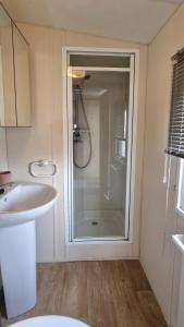 a bathroom with a shower and a sink at Serena Little Escape, West Sands Holiday in Selsey
