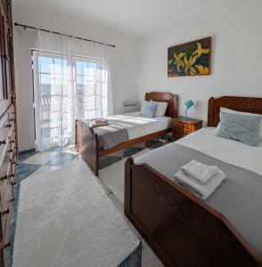 a bedroom with two beds and a window at Casa Machado in Sagres