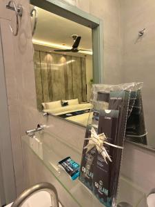 a bathroom counter with a mirror and a box on it at Go Glam Hotels Bahria Town in Rawalpindi +96 photos