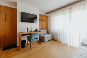 a bedroom with a desk and a chair and a bed at Weingut Kollerhof am Eichberg in Leutschach