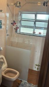 a bathroom with a toilet and a shower with a window at Apto completo,1 dorm, pé na areia na Cidade Praia Grande, praia mirim in Praia Grande +24 photos
