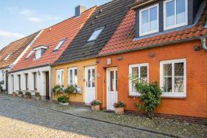 a row of orange and white houses on a street at Matthis Skipperhuus in Husum