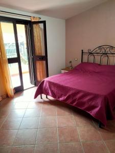 a bedroom with a bed with a purple bedspread on it at Casa Antonietta in Santa Lucia