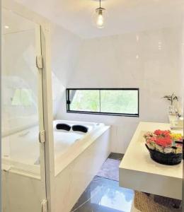 a white bathroom with a sink and a table at Chalé Suíço com Jacuzzi in Marechal Floriano