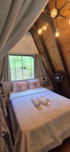 a bedroom with a large bed with two towels on it at Chalé Suíço com Jacuzzi in Marechal Floriano +6 photos