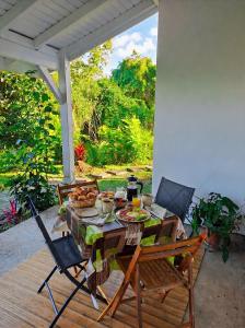 a table and chairs on a patio with food on it at De l'îlet au Volcan in Basse-Terre