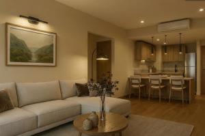 a living room with a white couch and a kitchen at Hotel Core Suites Estadio Akron in Zapopan