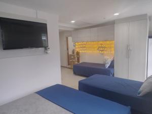 a bedroom with two beds and a flat screen tv at Inefável flat Porto Marina Resort in Mangaratiba