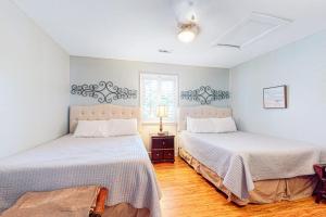 a bedroom with two beds and a window at Oceanbound in Folly Beach +6 photos