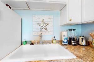 a kitchen counter with a sink and a starfish on the wall at Oceanbound in Folly Beach