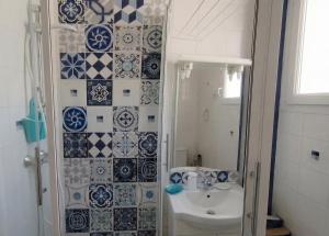 a bathroom with a sink and a shower with blue and white tiles at L'Indus -HyperCentre-WIFI-2à4pers in Saint-Nazaire +15 photos
