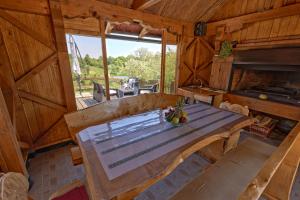 a large wooden table in a room with a large window at Kuća za odmor Holiday spa House Kostanjevec- Oaza mira ,bazen i spa in Velika Gorica