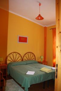 CiaramitiにあるVilla Soleの黄色の壁のベッドルーム1室(緑のベッド1台付)