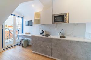 a kitchen with a sink and a microwave at Hygge Smart Stays in Lisbon