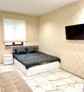 a bedroom with a bed and a tv on the wall at Троїцька площа 3 Квартира Самий Центр Окремий Вхід in Dnipro