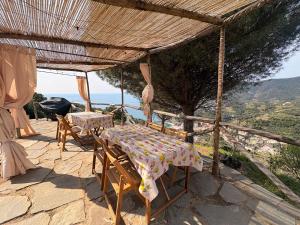 a table and chairs on a patio with a view of the ocean at Begasti guest house, for trekking lovers, free parking included in Monterosso al Mare