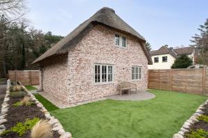 a large yard with a brick house with a grass at Küsten Kate in Ording +18 photos