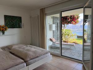 a bedroom with a bed and a sliding glass door at Casa Rocca Nera by HolAp in Ronco sopra Ascona