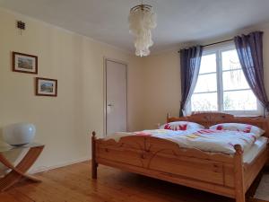 a bedroom with a wooden bed and a window at Viol in Filipstad