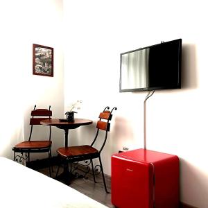 a room with a table and a tv and a red suitcase at Noemi Old Town in Braşov