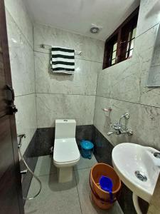 a bathroom with a white toilet and a sink at Sivasakthi Inn in Trivandrum