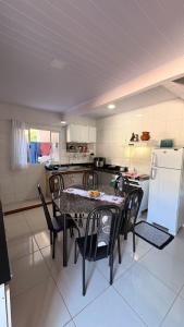a kitchen with a table and chairs and a refrigerator at Refúgio no Interior in Domingos Martins