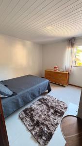 a bedroom with a bed and a table and a rug at Refúgio no Interior in Domingos Martins