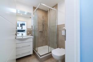 a bathroom with a shower and a toilet and a sink at Panoramic App B07-1 in Sierksdorf +25 photos