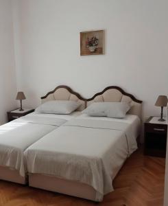 a bedroom with a large white bed with two lamps at Budva City - Villa Antic - Private Pool in Budva +18 photos