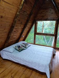 a bed in a log cabin with a window at Alma Silvestre in Puerto Triunfo