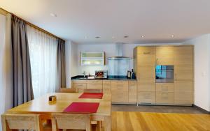 a kitchen with a wooden table and a large kitchen at ZermHaus - in the village center - very comfortable in Zermatt