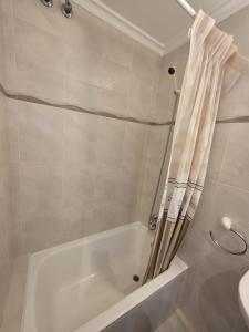 a white bath tub with a shower curtain in a bathroom at Hostal Restaurante Piedra in Limpias +211 photos