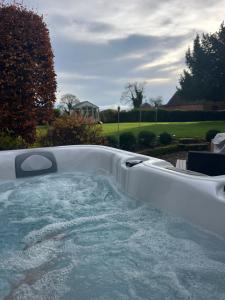 a jacuzzi tub with water in a yard at The TreeHouse Hideaway in Shrewsbury