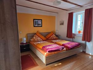 a bed in a room with a window at Pension Pastoriushaus in Bad Windsheim