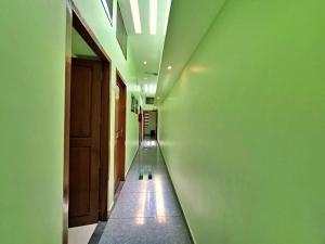 a hallway with a green wall and a ceiling at Sivasakthi Inn in Trivandrum