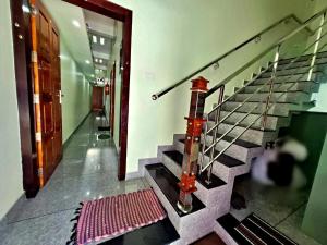 a staircase in a building with a red rug at Sivasakthi Inn in Trivandrum