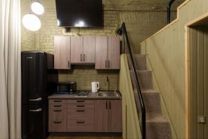 a small kitchen with a refrigerator and a staircase at Апарат готель під ЗОЛОТИМ КОРАБЛЕМ двохрівнева студія in Chernivtsi